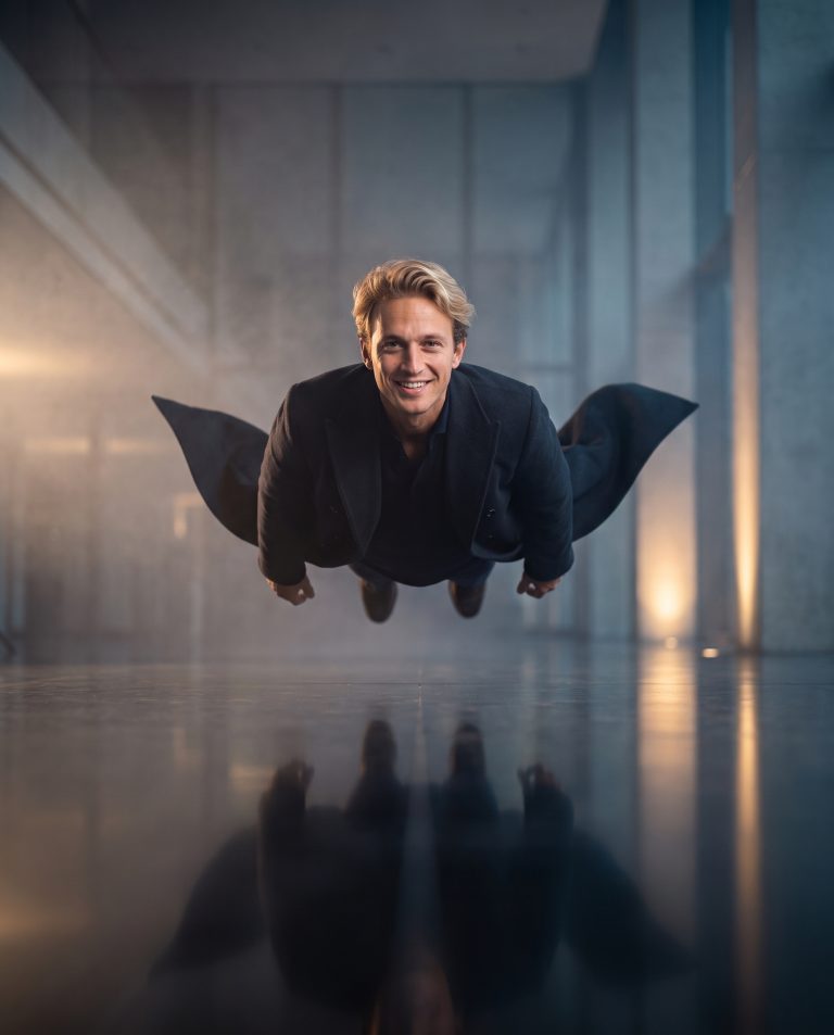 A guest floats serenely a foot above a polished reflective floor, body relaxed and weightless.