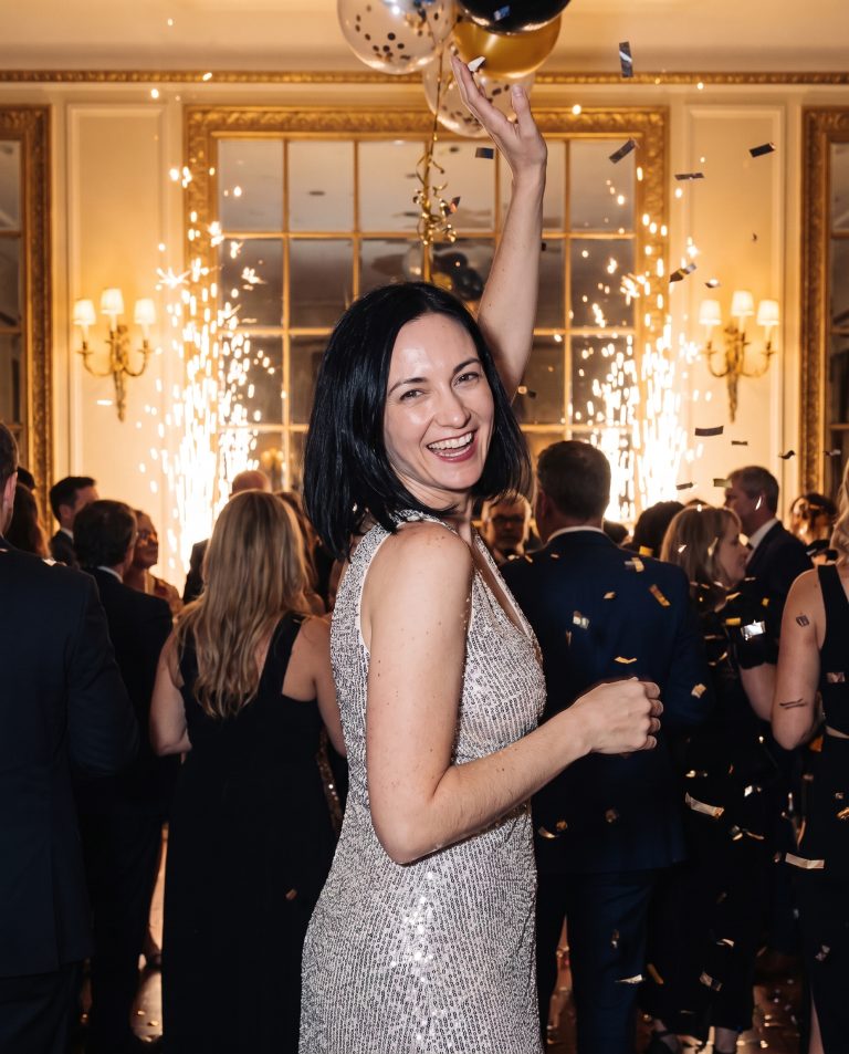 A guest is at the center of a packed New Year's Eve ballroom at the stroke of midnight.