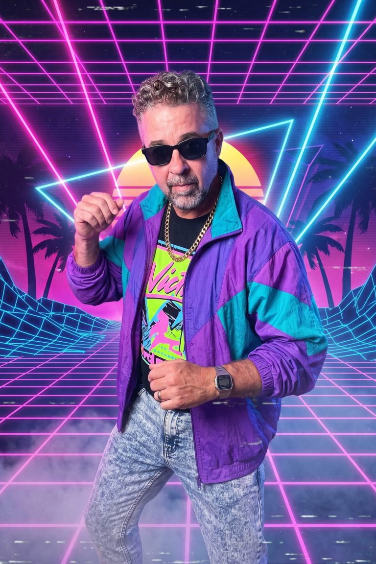 A guest in sunglasses, a gold chain and a purple and teal windbreaker strikes a pose in front of a neon grid and a setting sun