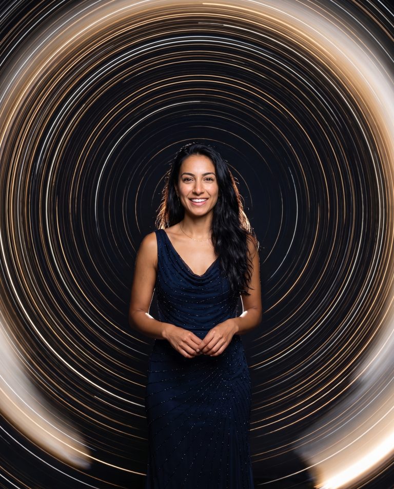 A guest stands sharp and perfectly still at the center of a long-exposure star-trail effect.