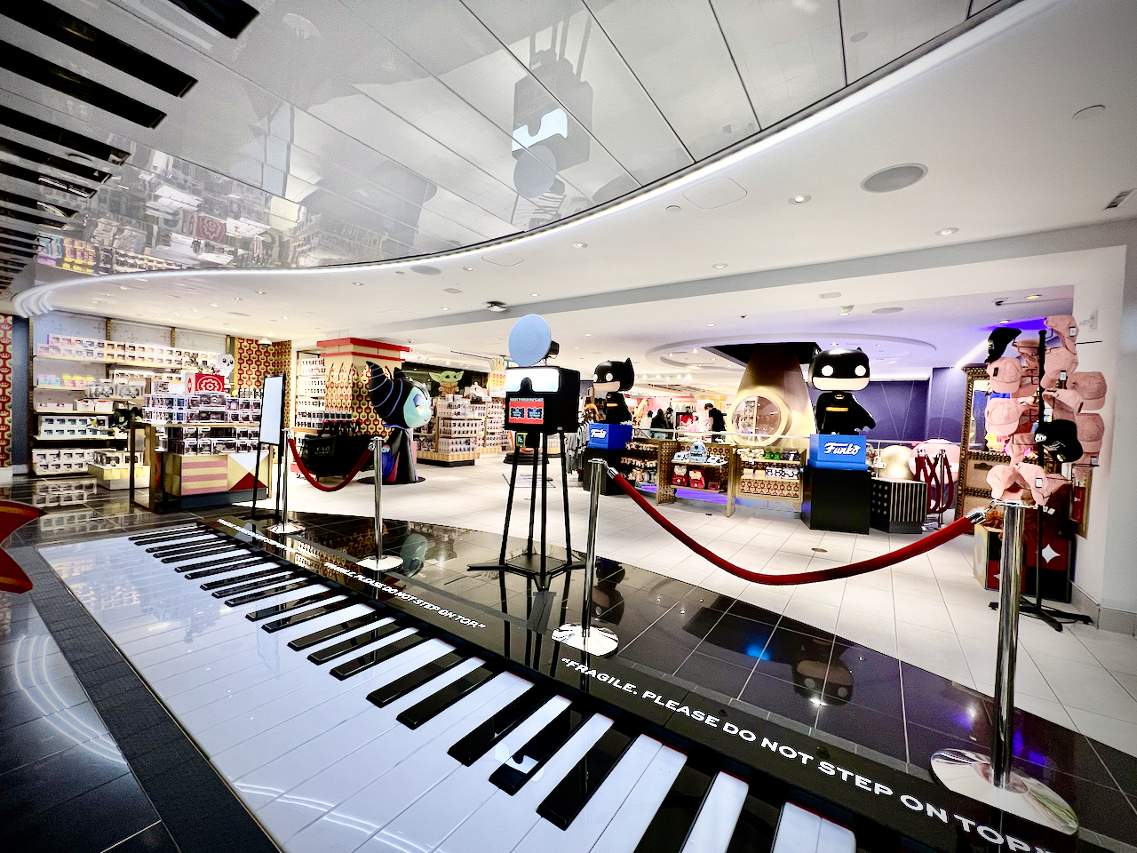 Studio Booth XL open-air photo booth permanently installed on the FAO Schwarz flagship retail floor beside the giant walking piano